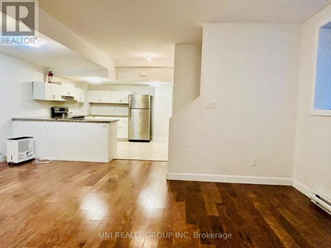 A kitchen with white cabinets and a wooden floor.