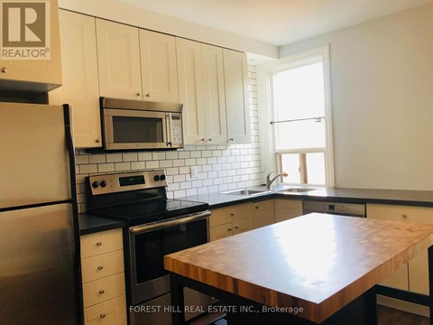 A kitchen with Forest Hill Real Estate Inc. signage.