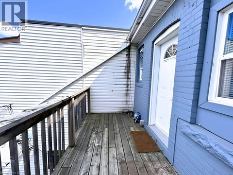 A wooden deck with a white door and a window.