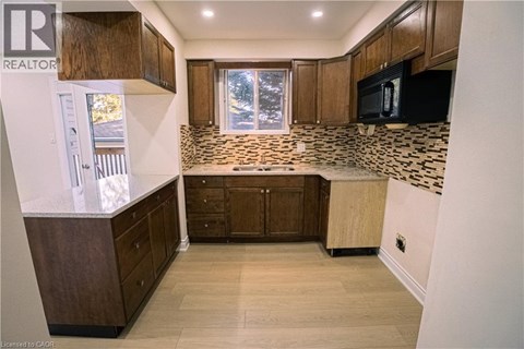 A kitchen with wooden cabinets and a tiled backsplash.