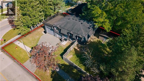 A large house with a grey roof is surrounded by trees.