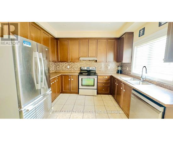 A kitchen with wooden cabinets and a stainless steel refrigerator.