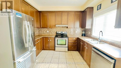 A kitchen with wooden cabinets and a stainless steel refrigerator.