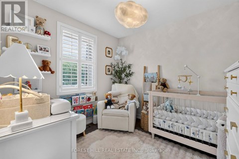 A nursery room with a white crib and a teddy bear.