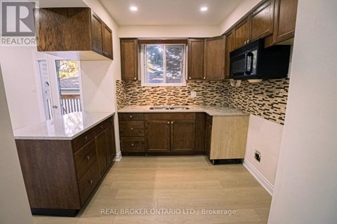 A kitchen with wooden cabinets and a tiled backsplash.