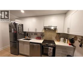 A kitchen with a refrigerator, oven, and sink.