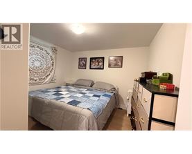 A bedroom with a bed, dresser, and two pictures on the wall.