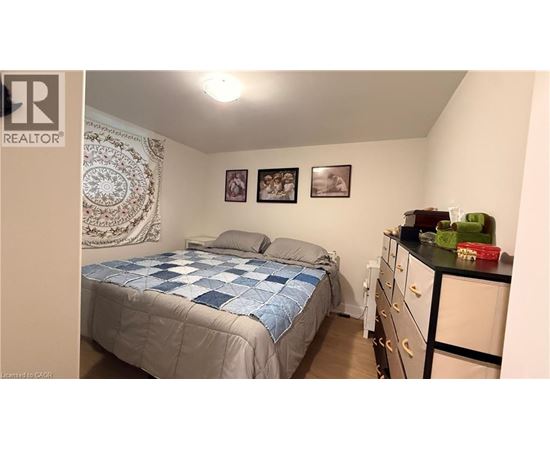 A bedroom with a bed, dresser, and two pictures on the wall.
