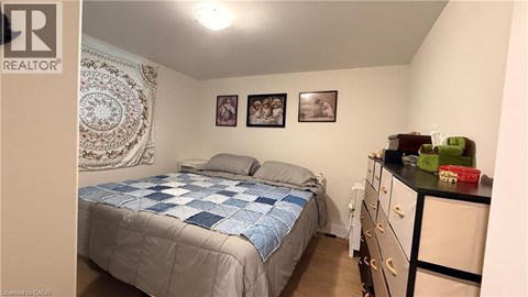 A bedroom with a bed, dresser, and two pictures on the wall.