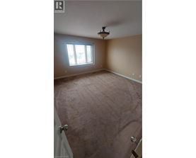 A room with a window and a light fixture on the ceiling.