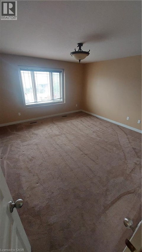 A room with a window and a light fixture on the ceiling.