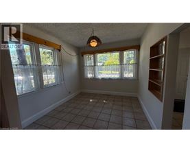 A room with a tiled floor and a window with a view of trees.