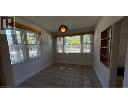 A room with a tiled floor and a window with a view of trees.