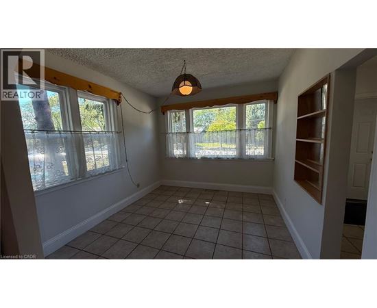 A room with a tiled floor and a window with a view of trees.
