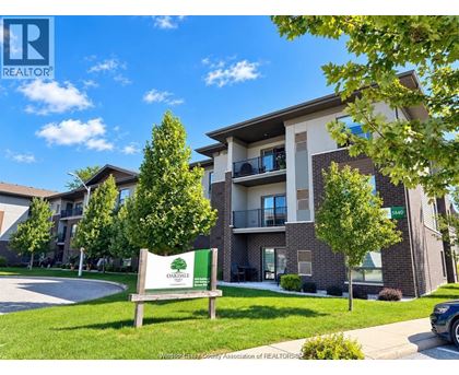 A sign for Oakridge Apartments stands in front of a building with balconies.