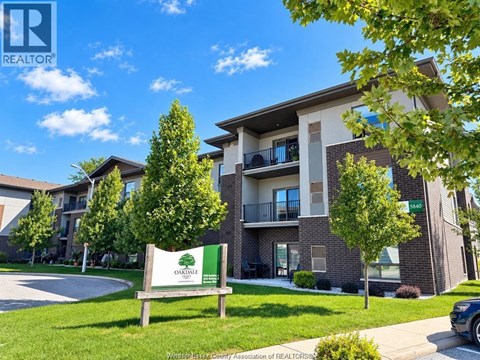 A sign for Oakridge Apartments stands in front of a building with balconies.