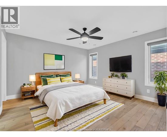 A bedroom with a bed, nightstands, and a television.