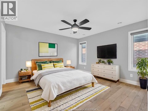 A bedroom with a bed, nightstands, and a television.