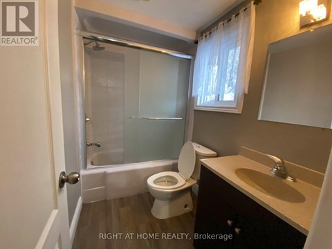 A bathroom with a toilet, sink, and shower.