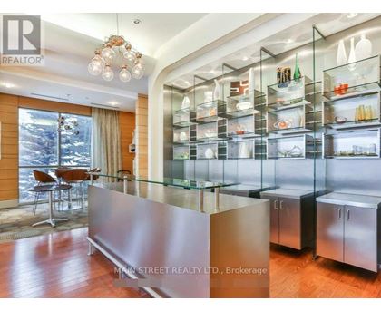 A modern kitchen with a glass display cabinet and a wooden floor.