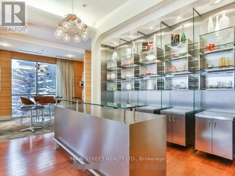 A modern kitchen with a glass display cabinet and a wooden floor.