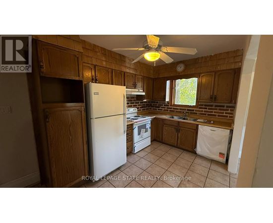 A kitchen with wooden cabinets and a white refrigerator.