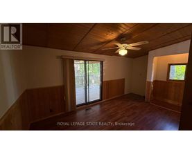 A room with wooden walls and a ceiling fan.