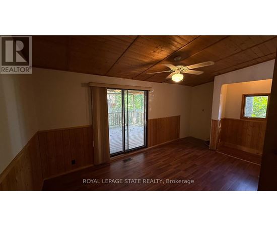 A room with wooden walls and a ceiling fan.
