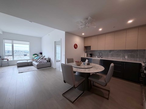 A modern kitchen with a dining table and chairs.