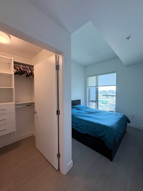 A bedroom with a bed, a wardrobe and a window.