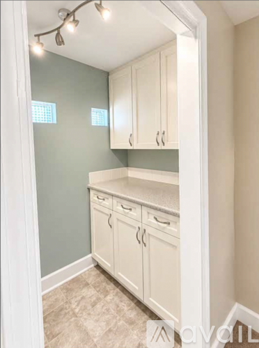 A kitchen with white cabinets and a countertop.