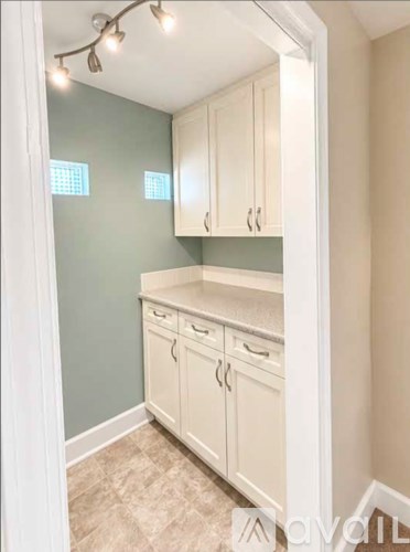 A kitchen with white cabinets and a countertop.