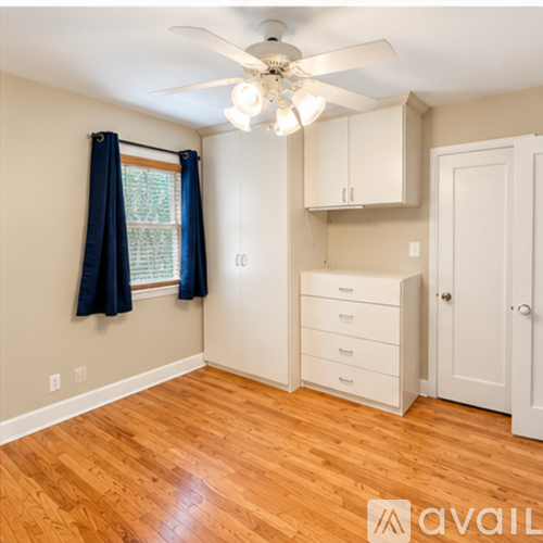 A room with a ceiling fan and wooden floors.