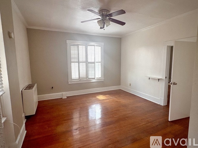 A room with a ceiling fan and a window with blinds.