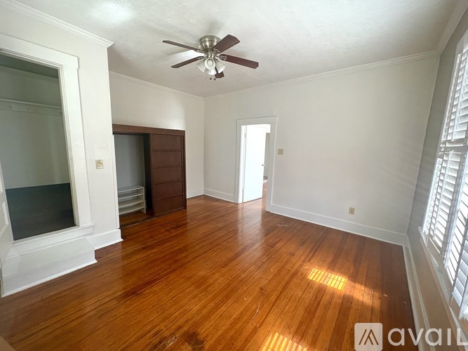 A room with wooden floors and a ceiling fan.
