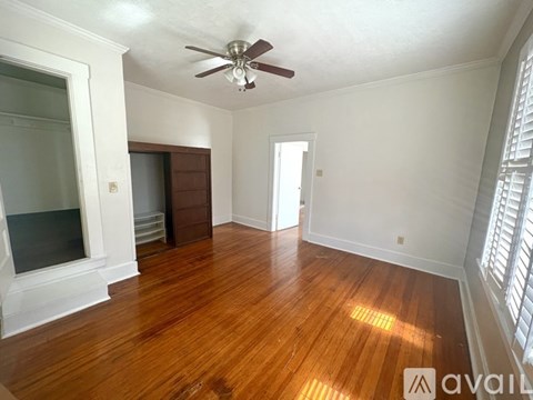 A room with wooden floors and a ceiling fan.