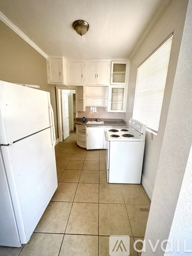 A kitchen with white appliances and cabinets.