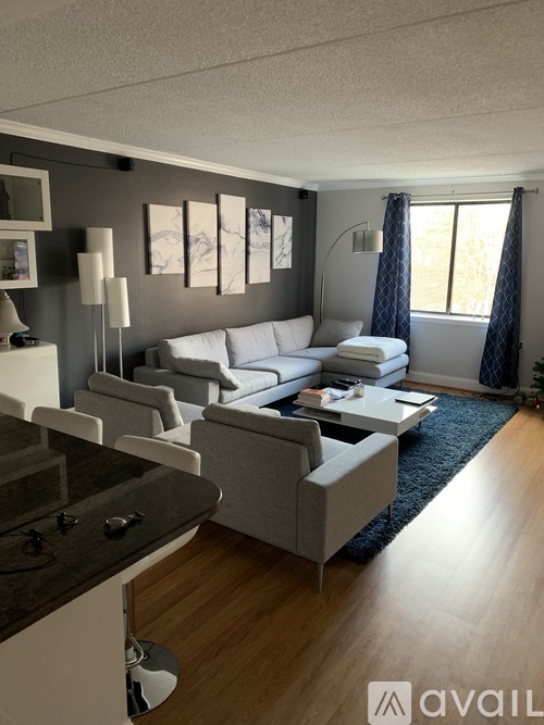 A modern living room with a grey sofa and a wooden floor.