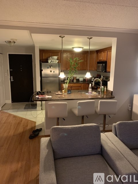 A kitchen with a table and chairs in the foreground and a refrigerator in the background.