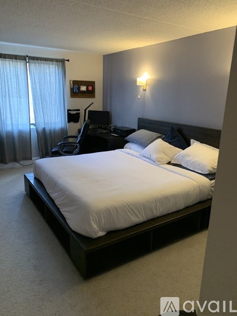 A bedroom with a large bed and a desk with a computer.