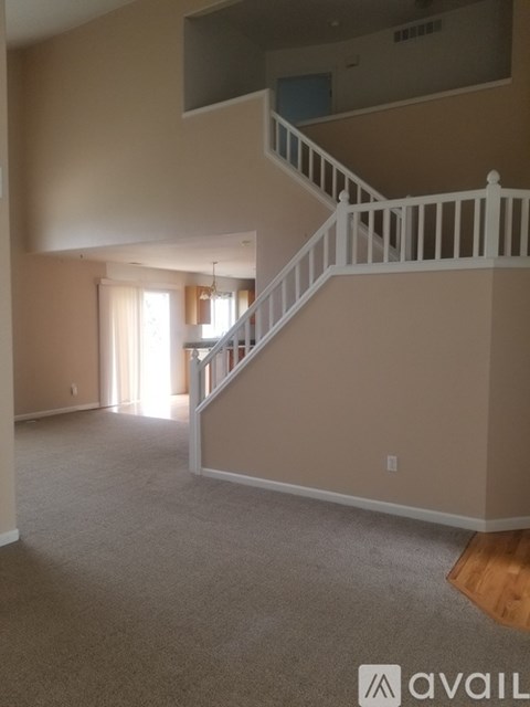 A spacious living room with a staircase leading to the upper level.