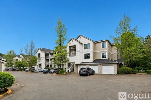 A large two-story apartment building with a parking lot in front.
