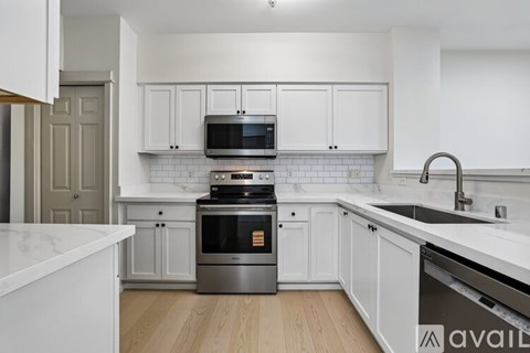 A kitchen with white cabinets and a black oven.