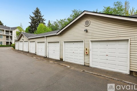 A row of white garage doors in front of a building.