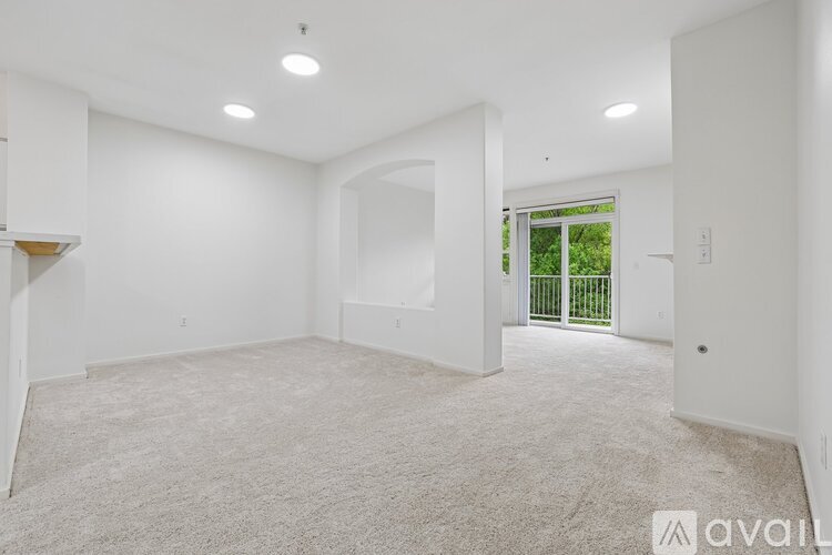 A spacious, empty room with a carpeted floor and white walls.