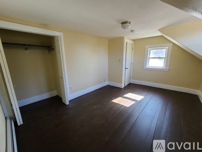 A room with wooden floors and a window on the wall.
