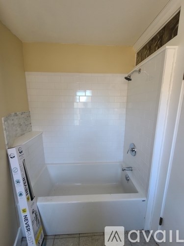 A bathroom with a white tub and a shower head.