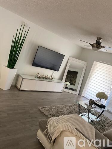 A living room with a flat screen TV mounted on the wall above a coffee table.