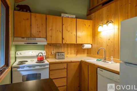 A kitchen with wooden cabinets and a white stove top oven.