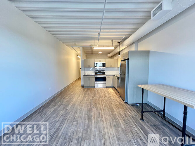 A long, narrow room with a kitchenette and a bench.
